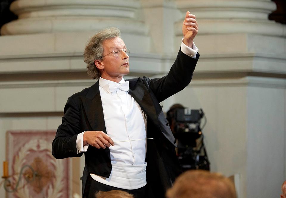 Ögonblicksbild på dirigenten när han dirigerar. Festklädd. Fotografi.