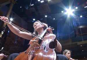 Kvinna som spelar cello. Fotografi.