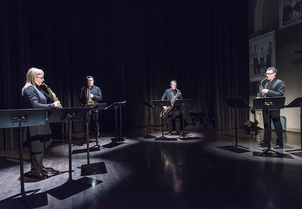 Fyra musiker som spelar. Fotografi.