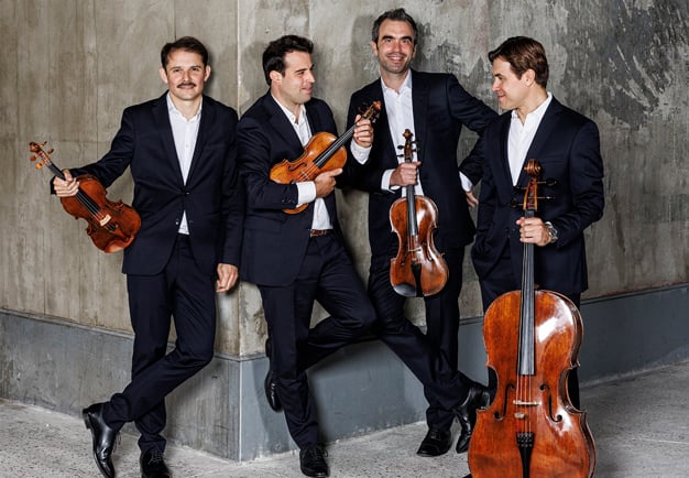 Fyra män som håller i instrument. Fotografi.