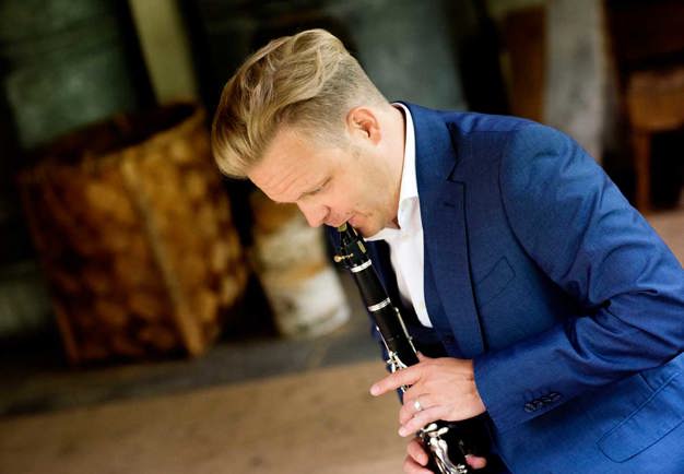 Christoffer plays his clarinett. Picture taken in profil. Photo.