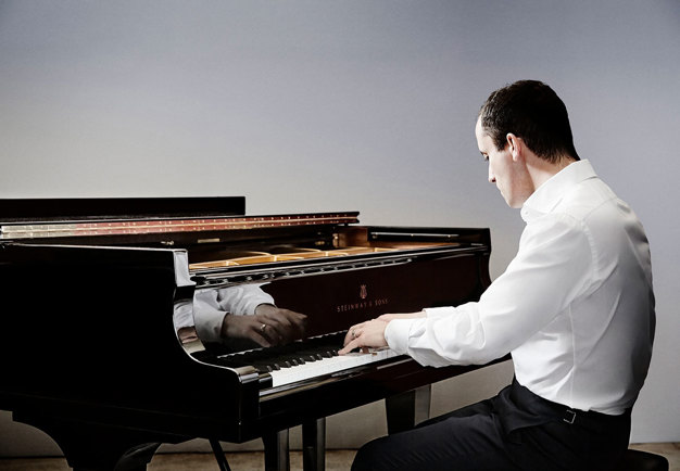 Igor Levit by his piano. Photo.
