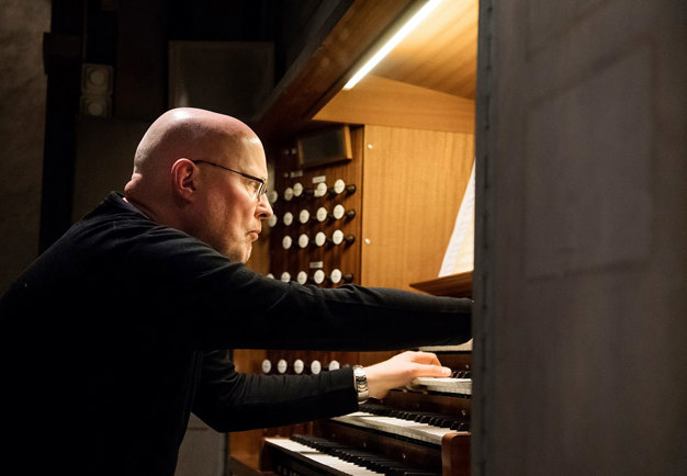 Photo of a man playing a organ.
