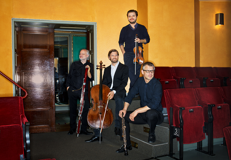Fyra musiker med sina instrument. Fotografi.