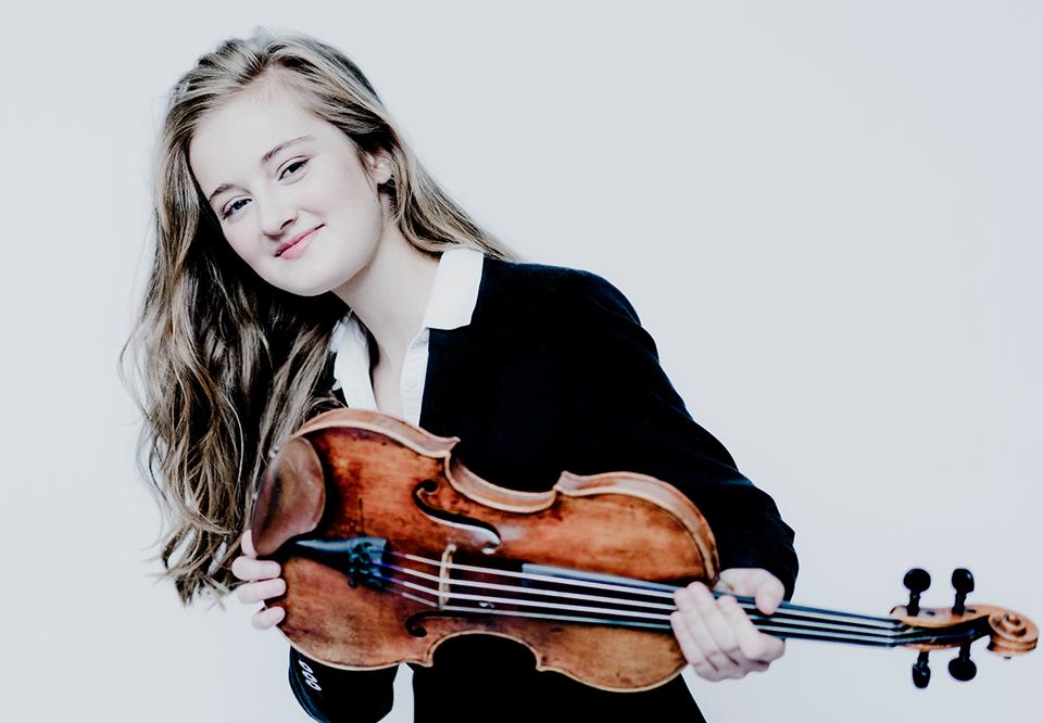 Picture of woman with long hair holding in her violin, photo.