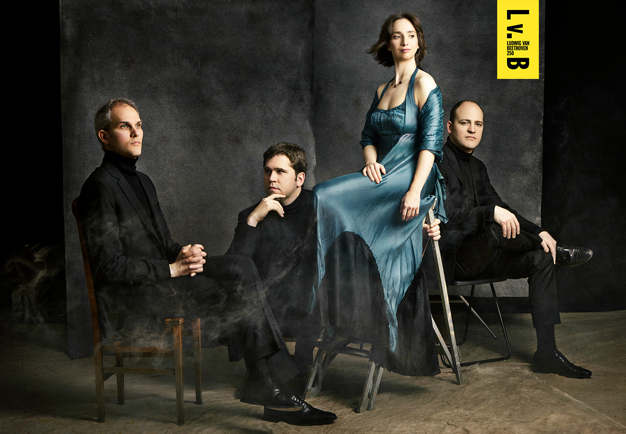 Four people sitting in chairs. Photo.