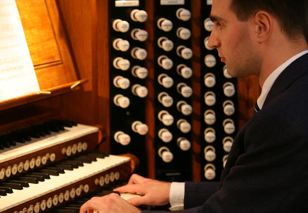 Man som spelar orgel. Fotografi.
