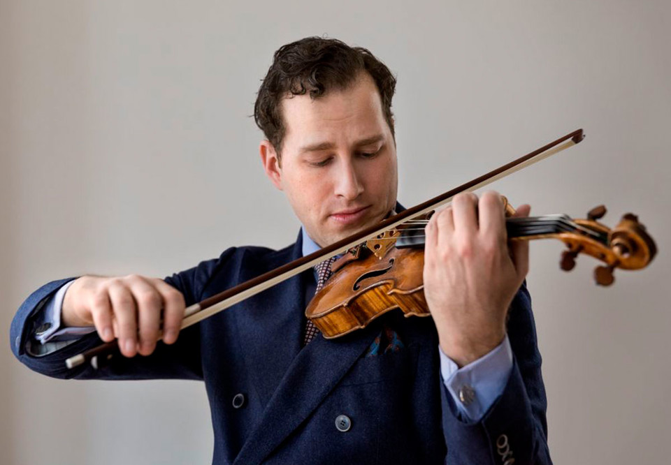 Close up photo of a man playing the violin. 