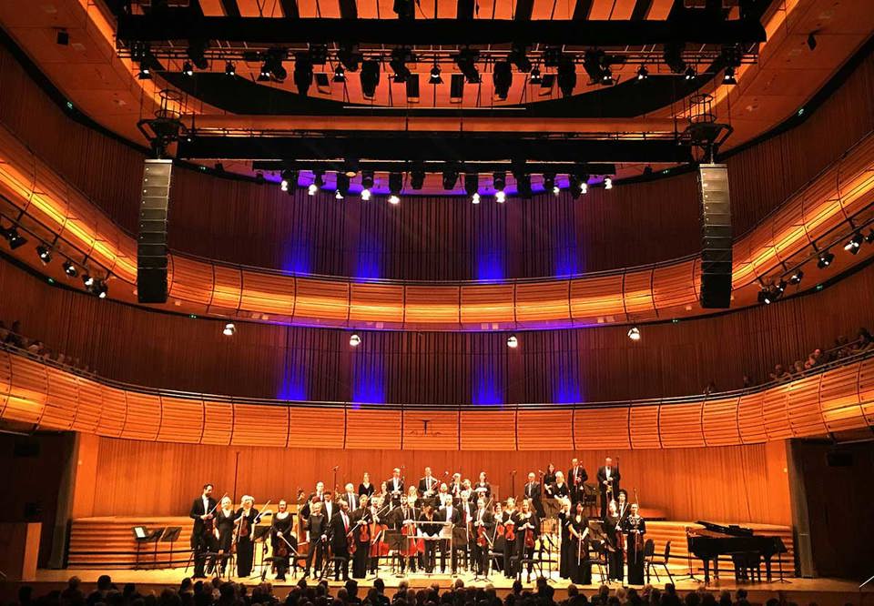 bild på orkester i vacker sal. Fotografi