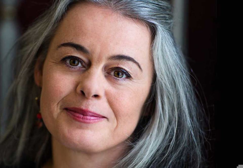 Close up photo of a woman with long grey hair. 