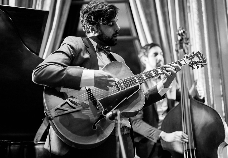 Man som spelar gitarr. Fotografi.