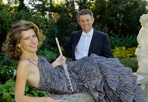 Woman with a flute and a man in dark suit. Photo.. Fotografi.