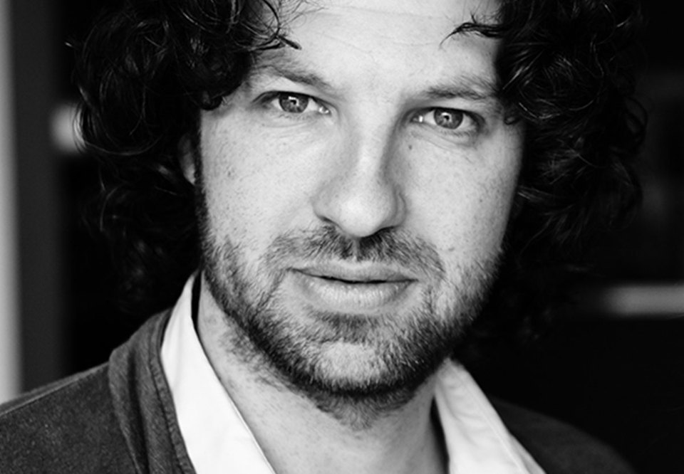 Black and white photo of a man in dark hair. 