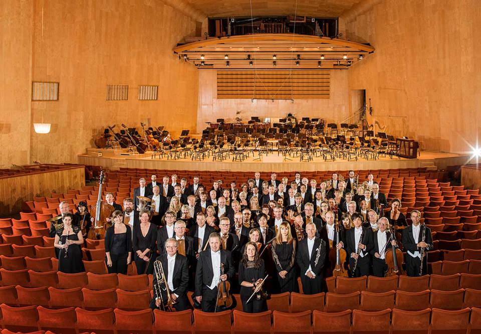 Photo of a  orchestra in  a concert hall.