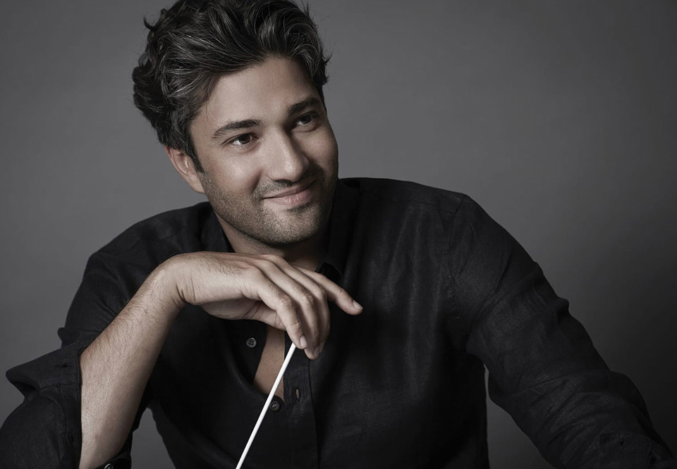 Close up photo of a smiling man with a baton.