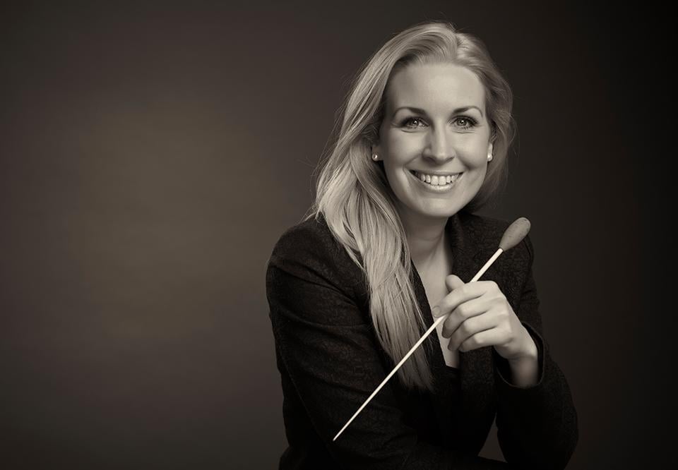 Svartvitt fotografi på kvinna som håller dirigentpinne