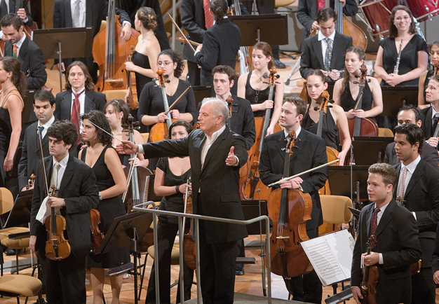 Orkesterbild med dirigent vänd ut mot publiken. Dirigenten har utsträckta armar. West-Eastern Divan Orchestra och Daniel Barenboim. Fotografi.