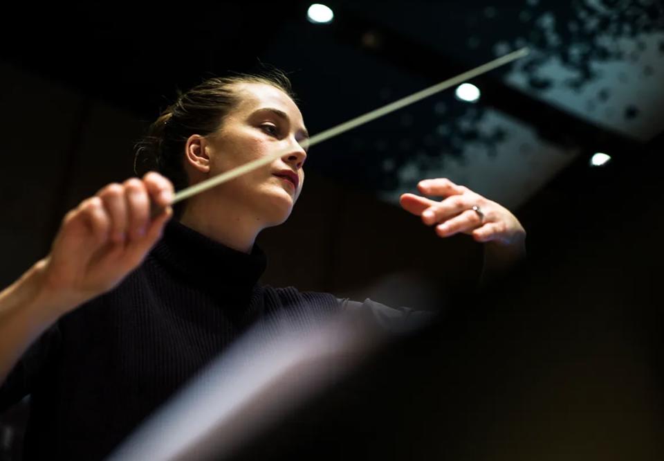 Kvinna som dirigerar. Fotografi.