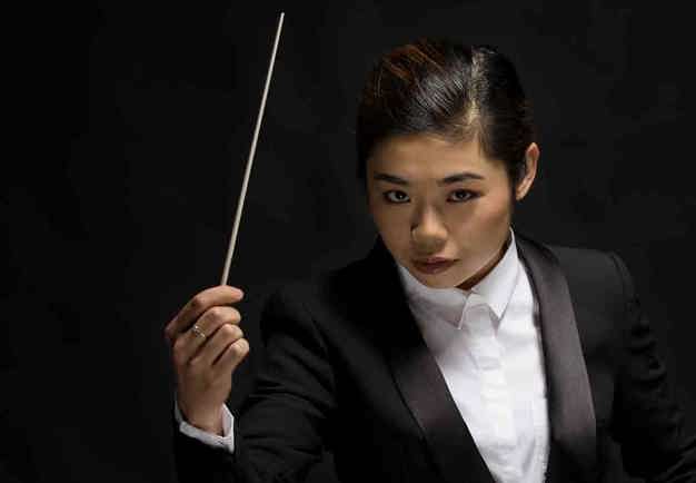 Elim Chan conducts with focus. Photo.