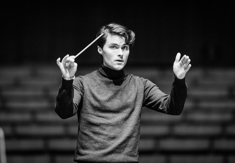 Black and white photo of a young guy who conducts. Photo.