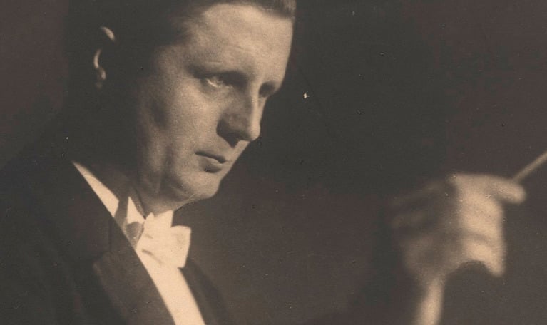 Man i profil håller i dirigentpinne. Porträtt på dirigenten Fritz Busch. ett svart-vitt äldre fotografi.