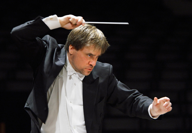 Intense moment of John Storgårds, raising the baton with great focus and concertration. Photography.
