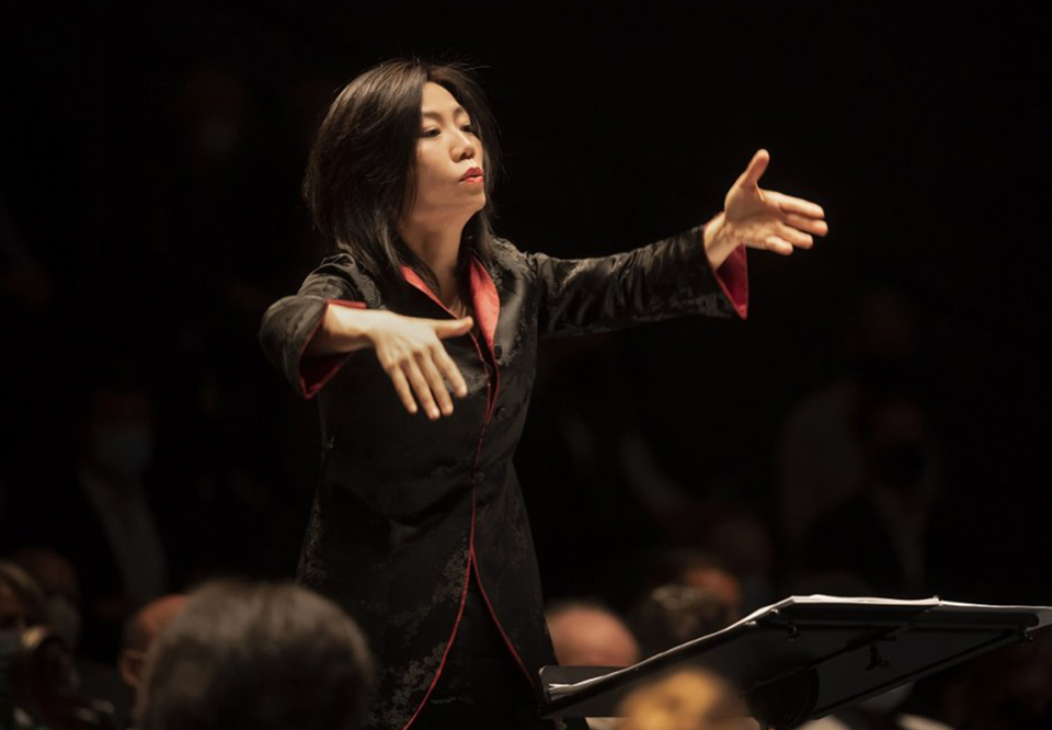 Kvinna som dirigerar. Fotografi.