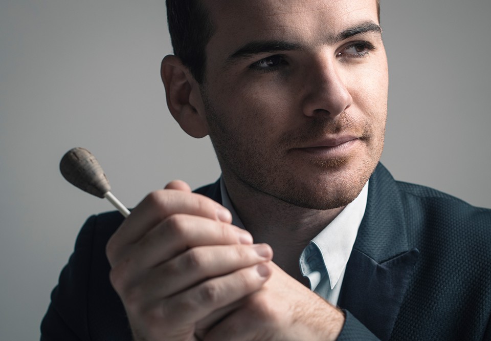 Close up photo of a smiling man with a baton. 