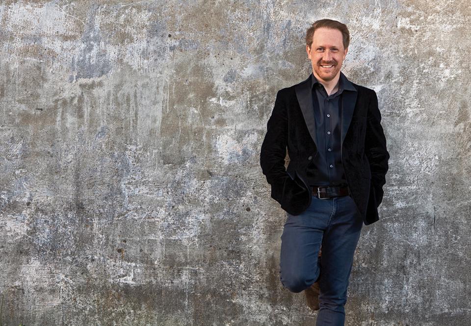 Man standing against a grey wall. Photo.