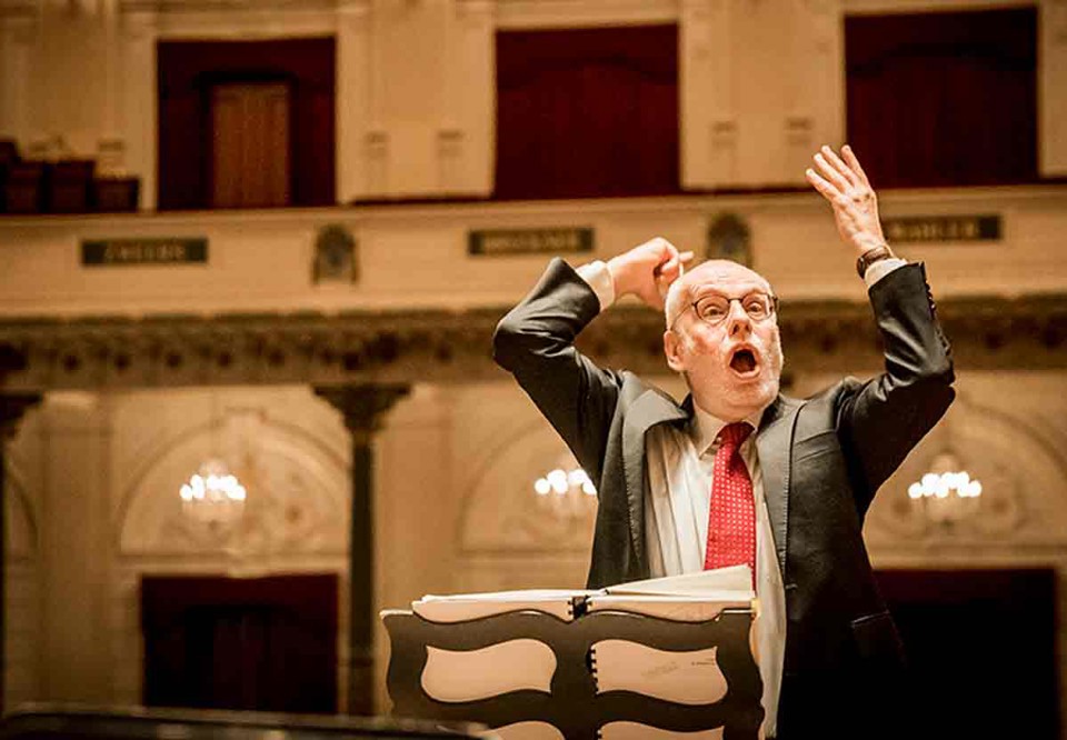 Energetic conductor on stage. Photo.