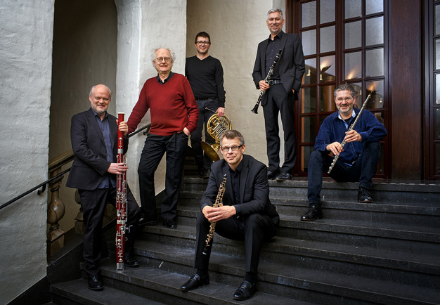 Sex män som står i en trappa med deras instrument. Foto.