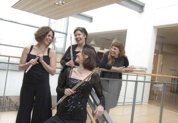 Four women with flutes standing in the stairs. Photo