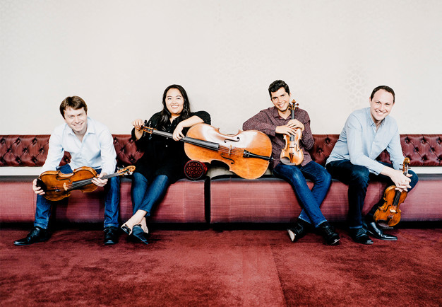 Fyra personer på rad. Fotografi.