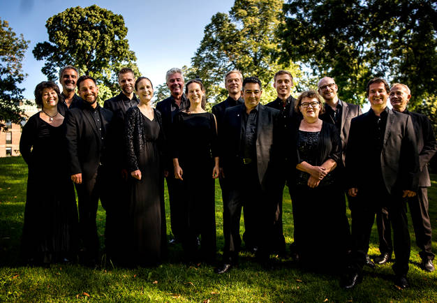 A group photo of black dressed musicians.