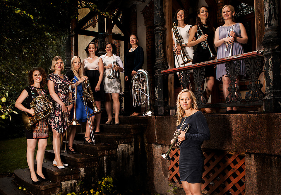 Ten girls holding different brass instruments. Photography.