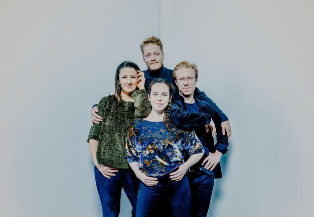 Group photo of four people playiong their string instruments. 