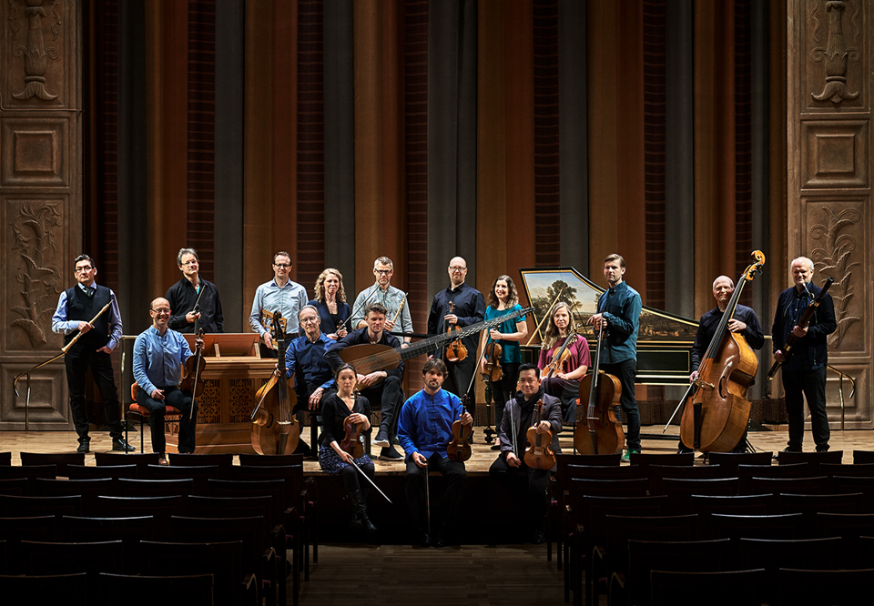 Orfeus Baroque ensemble, the whole group photographed in a hard light.