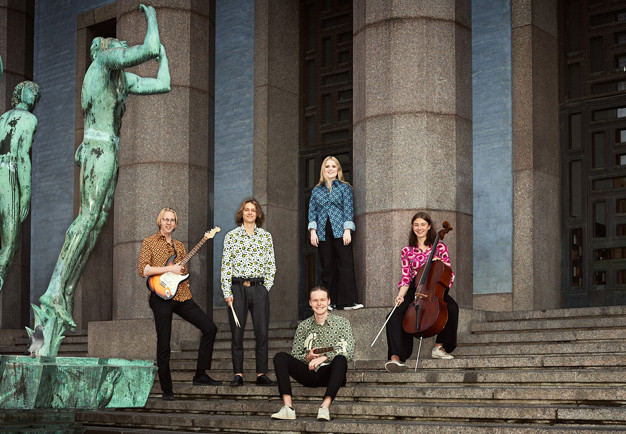 Unga musiker som står på Konserthusets trappa. Fotografi.