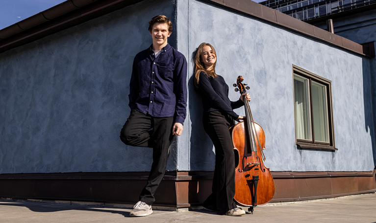 Two musicians leaning against a wall. Photo.