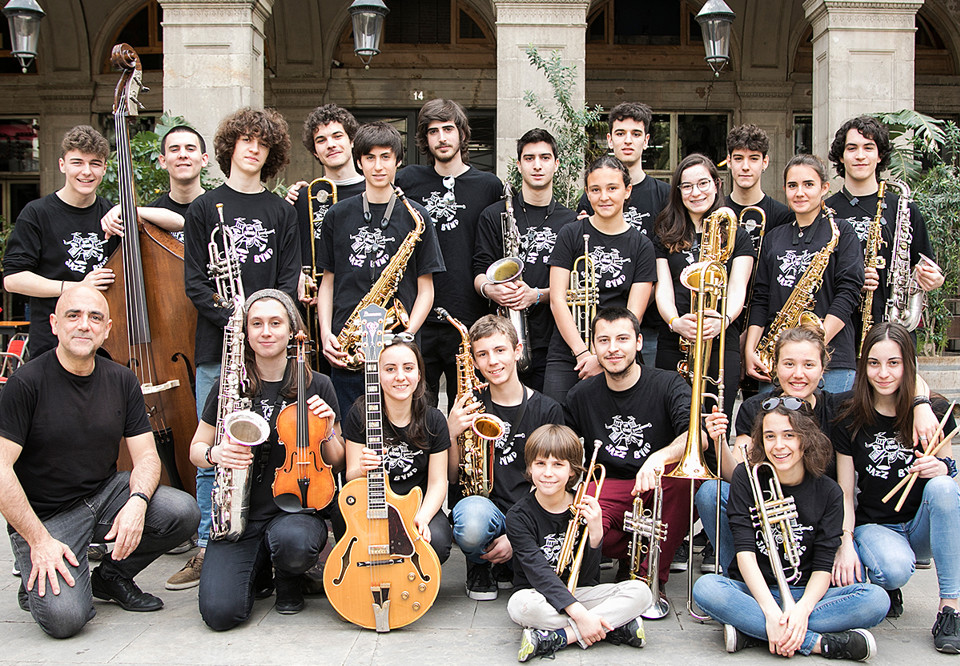 Young people sitting and standing with ijnstruments i their hands. Photo.