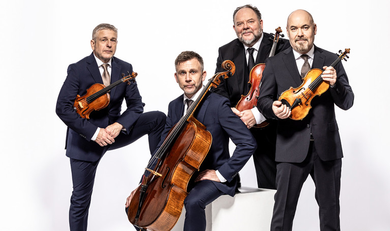 Fyra unga musiker med instrument. Fotografi.