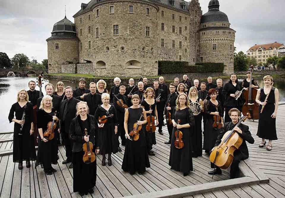 Gruppfoto på hela orkestern framför ett slott.