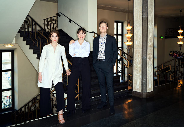 Three persons standing in a corridor