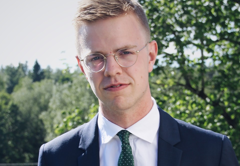 Porträttbild på Arvid som ser rakt in i kameran. Somrig suddig bakgrund.
