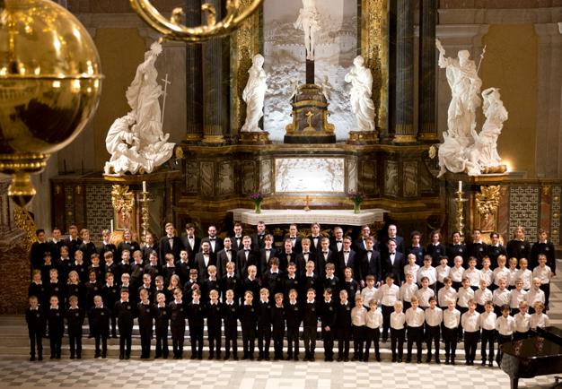 Fotografi av gosskören i konsertklädsel i en kyrkosal.