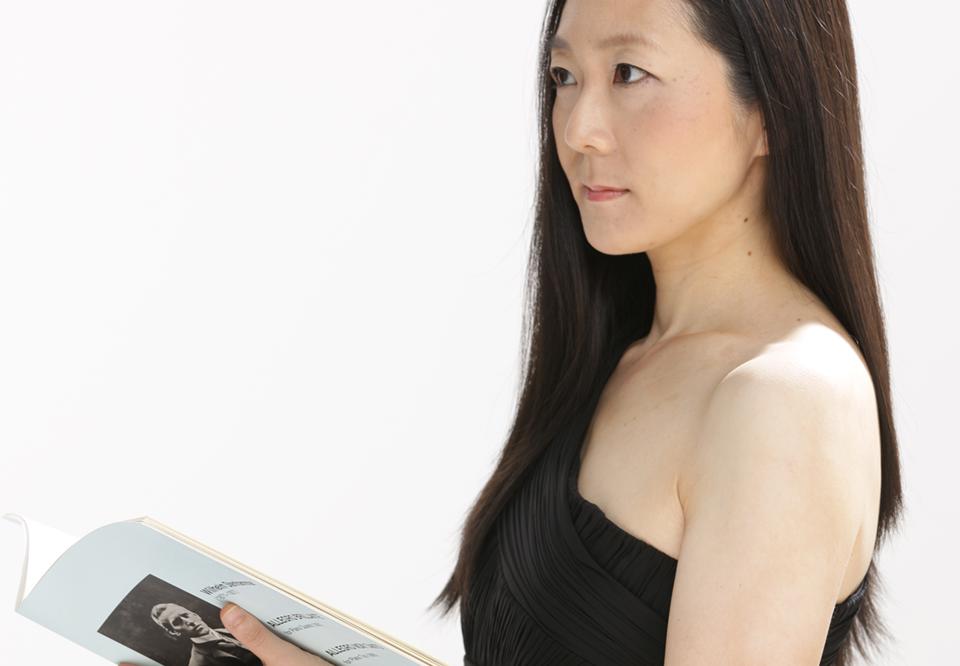 Porträttbild på Kiyo Wada som håller i ett partitur och blickar bort.