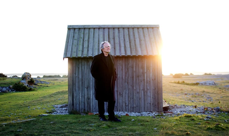 Man vid hus. Fotografi
