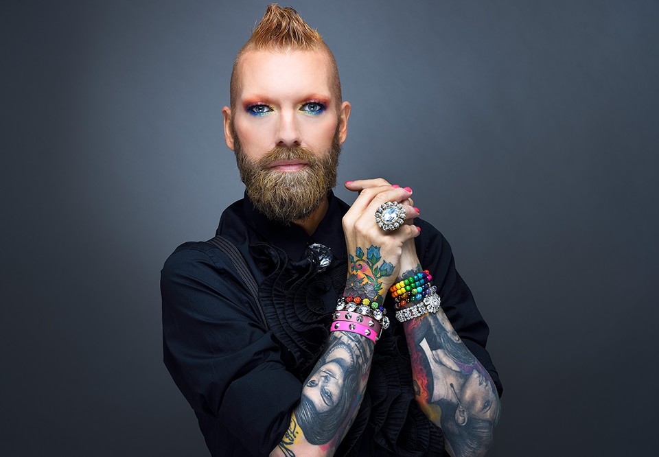 Man som tittar in i kameran med fina tatueringar. Fotografi.