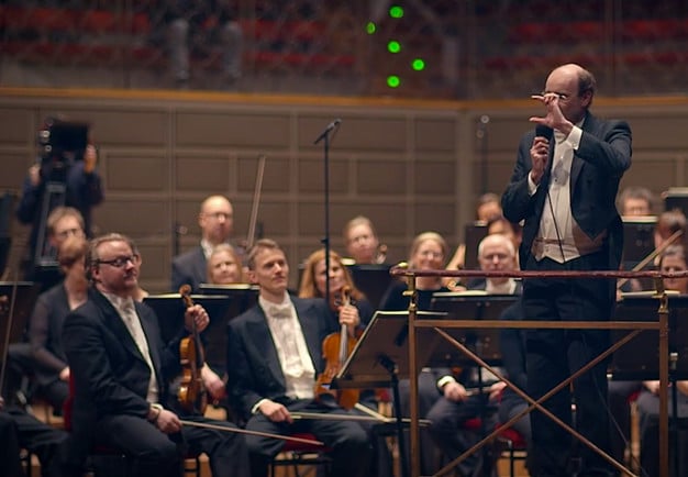 Conductor standing in front of a large orchestra. From the concert.