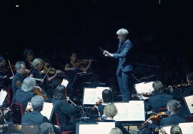 Man conducting a large orchestra. From the concert.
